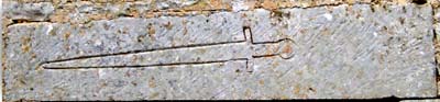 Commanderie d'Ensigné : pierre tombale utilisée en linteau